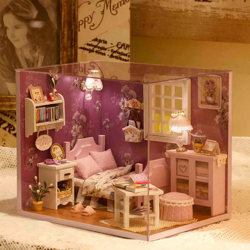 A detailed wooden miniature dollhouse kit featuring pink furniture and decorative elements.