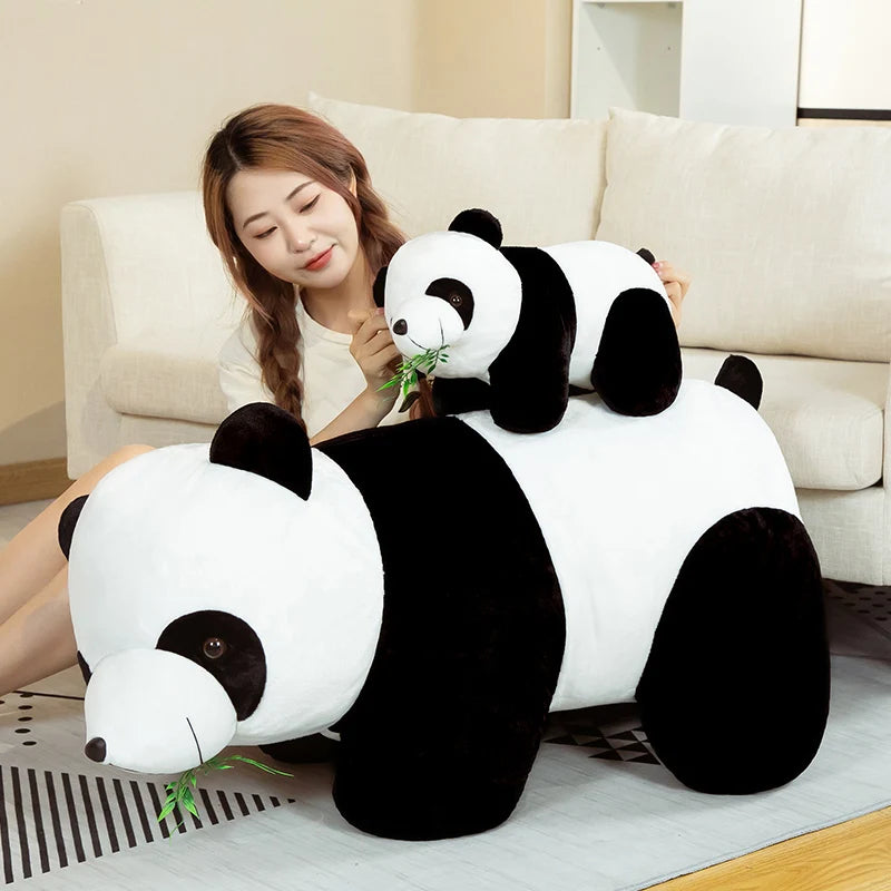A white and black bamboo panda plush stuffed animal sitting on a light-colored sofa.