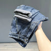 A close-up of vintage loose fit denim harem jeans folded and displayed on a person's leg.