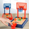 A hand is interacting with a mini tabletop basketball arcade game set featuring red and blue components.