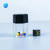 A clear cube with a black top containing colorful dice, next to a single black and yellow die.