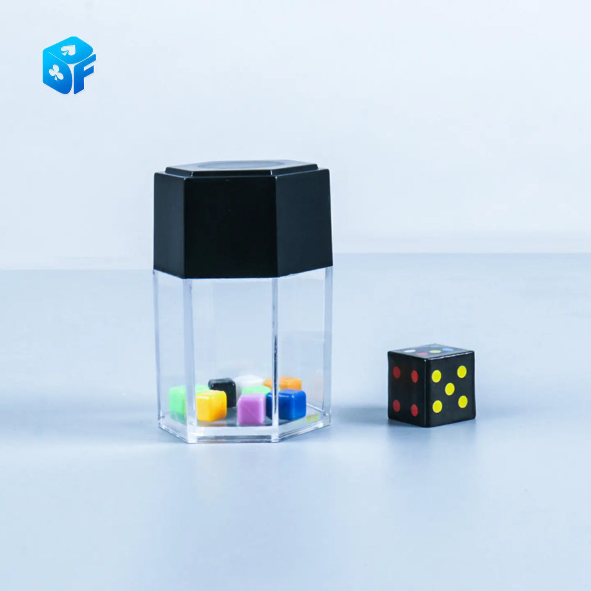 A clear cube with a black top containing colorful dice, next to a single black and yellow die.