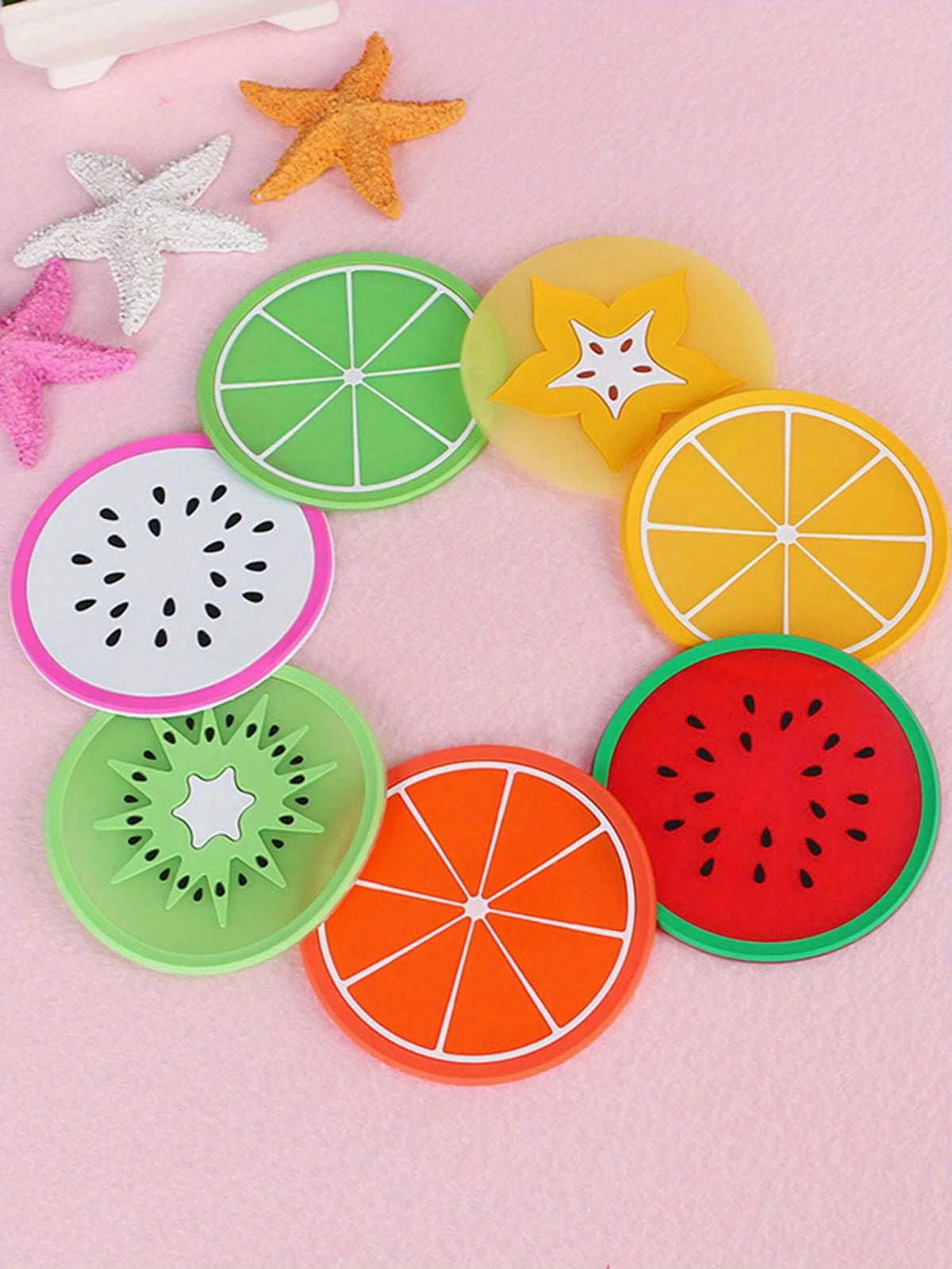 A set of colorful fruit pattern PVC coasters including lime, starfruit, orange, watermelon, and kiwi designs.