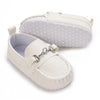 A pair of white baby first walker sneakers with a light purple lining and a matching padded cover.