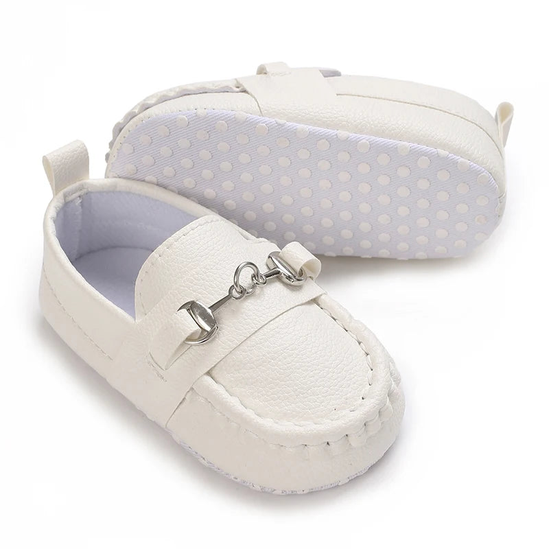 A pair of white baby first walker sneakers with a light purple lining and a matching padded cover.