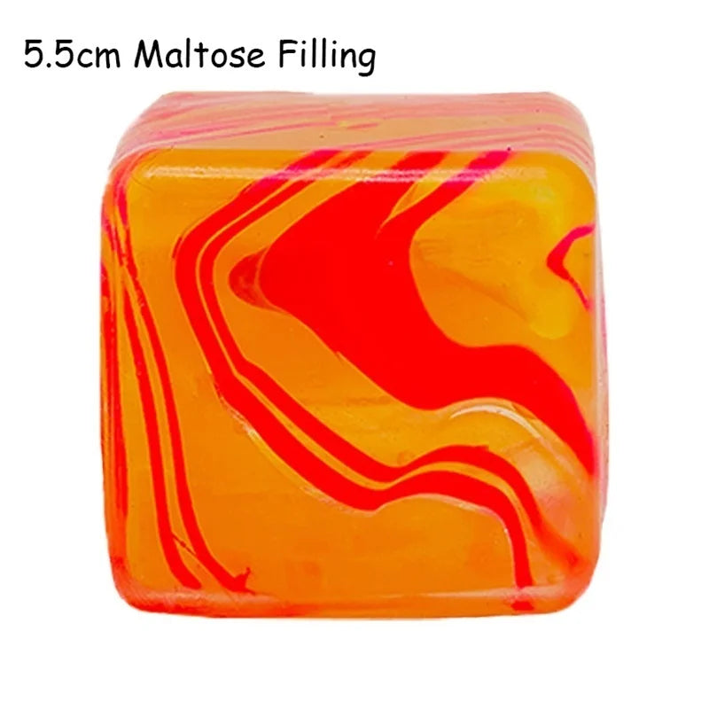 An orange cube toy filled with red and yellow marbled liquid, used for natural maltose relief.