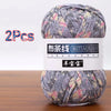 A ball of soft chunky t-shirt yarn in a patterned mix of gray, white, and pink is shown.