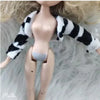 A fashion doll with long blonde hair wearing a black and white striped fur outfit.