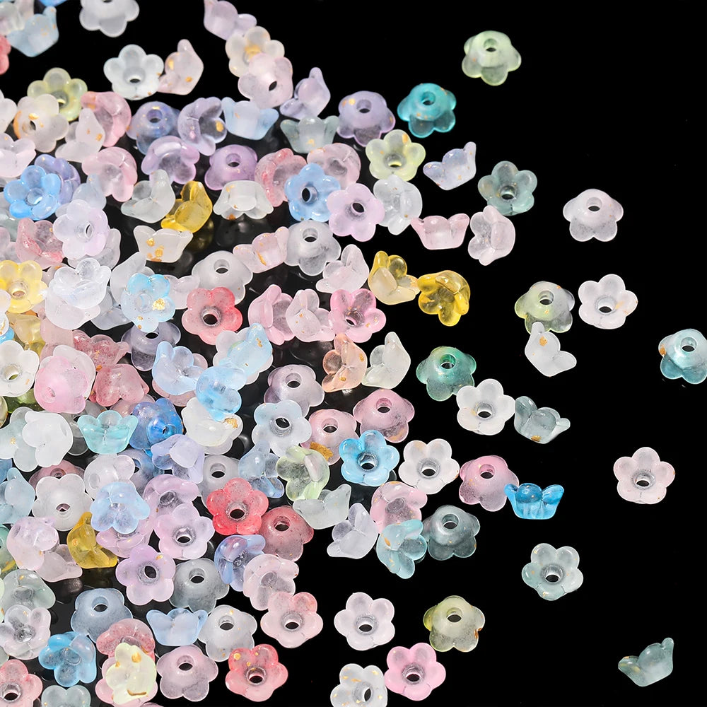 A collection of small, gradient colored acrylic bellflower beads in various shades of pink, blue, and yellow.