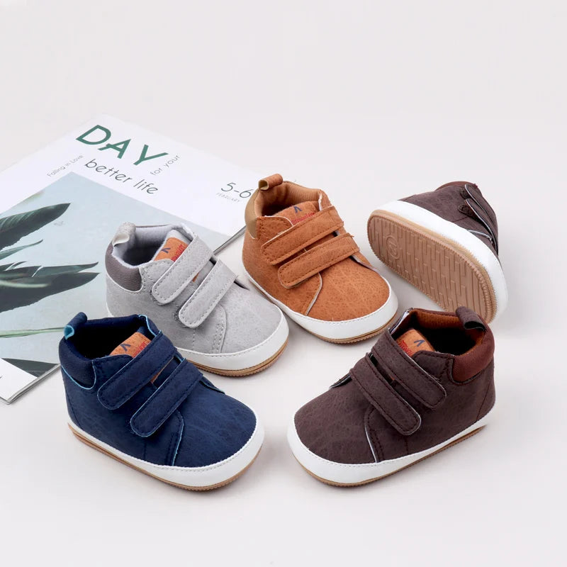 A collection of soft PU leather baby first walker shoes in various earthy tones including brown, gray, and navy blue.