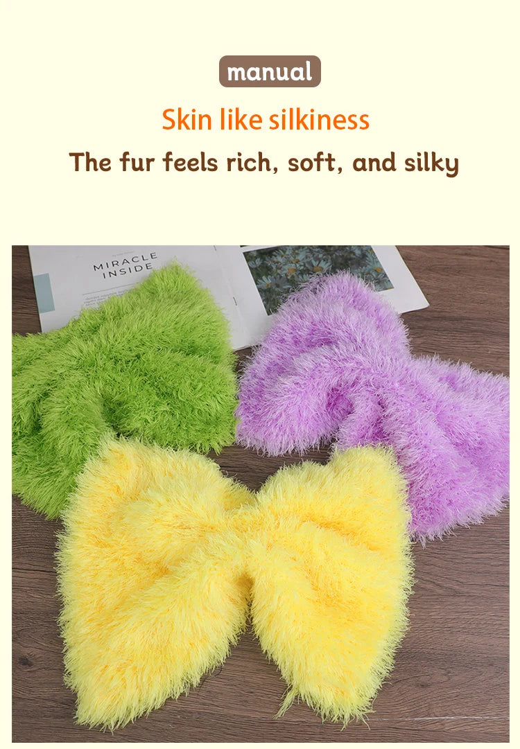 A close-up of three fluffy faux fur yarn skeins in green, purple, and yellow.