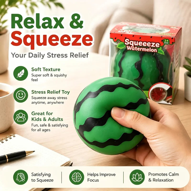 A hand holds a green watermelon squishy stress ball with a black striped pattern on a wooden table.