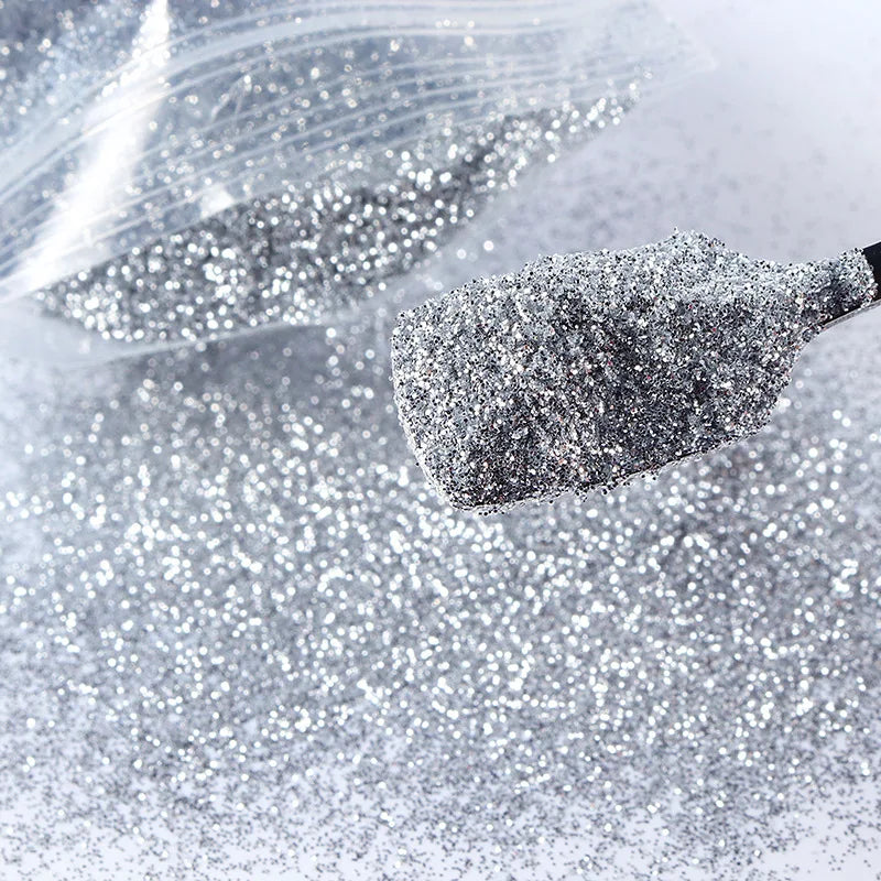 A close-up shot of holographic fine glitter powder being squeezed onto a surface for crafting projects.