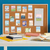 A framed display of watercolor stickers depicting mountain and sea scenery on a cork board next to art supplies.