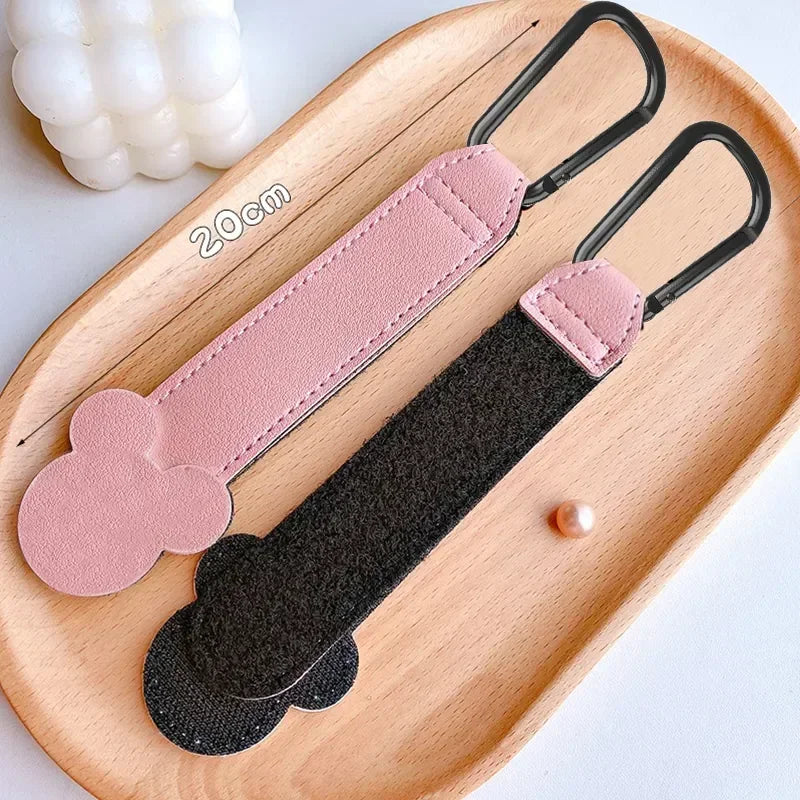 Pink and black PU leather stroller organizer hooks displayed on a wooden tray