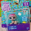 A plastic packaging box for a set of Littlest Pet Shop figures, including a light-colored dog figure and accessories.