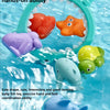 A colorful water-squirting turtle bath toy with a fishing net is shown floating in clear water.