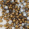 A close-up view of various flatback rhinestones in gold and silver tones for nail art and crafts.