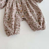 A light beige floral print baby girl jumpsuit with long sleeves and a doll collar detail.