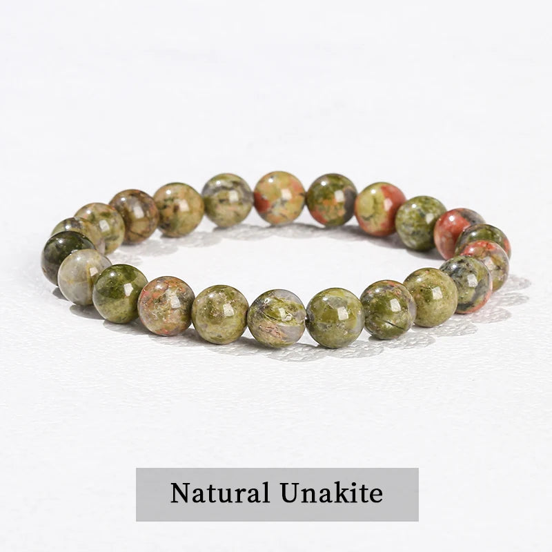 A bracelet made of natural unakite stones in shades of green and pink.