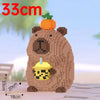 A brown capybara building block figurine with a green pumpkin on its head and a yellow cup accessory.