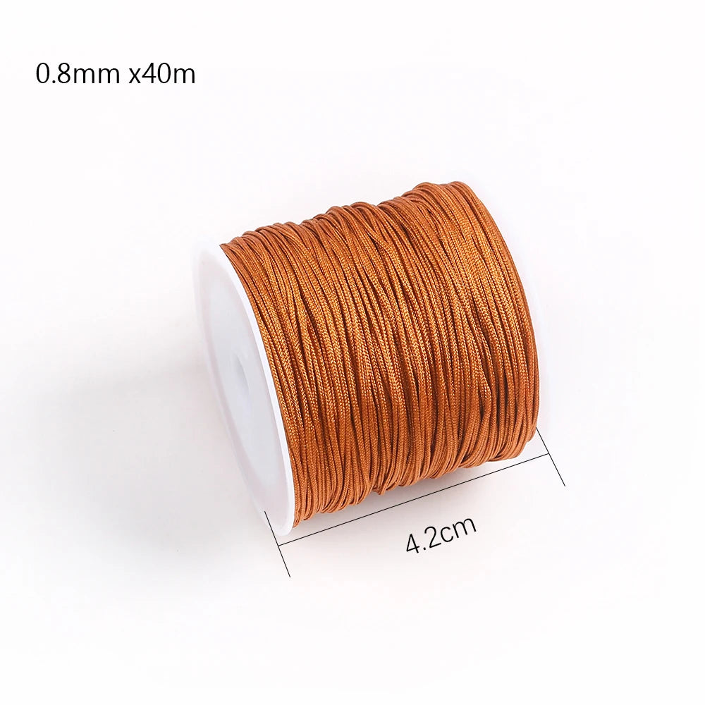 A roll of 0.8mm x 40m orange cotton nylon macrame cord for jewelry making and crafts.