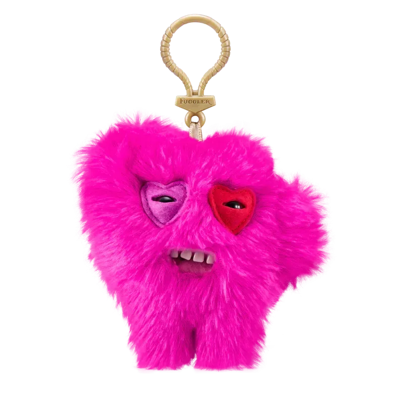 A bright pink plush monster keychain with a heart face and teeth, featuring a quirky rabbit design.