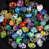 A collection of seven polyhedral resin dice in various colors and shapes for tabletop gaming.