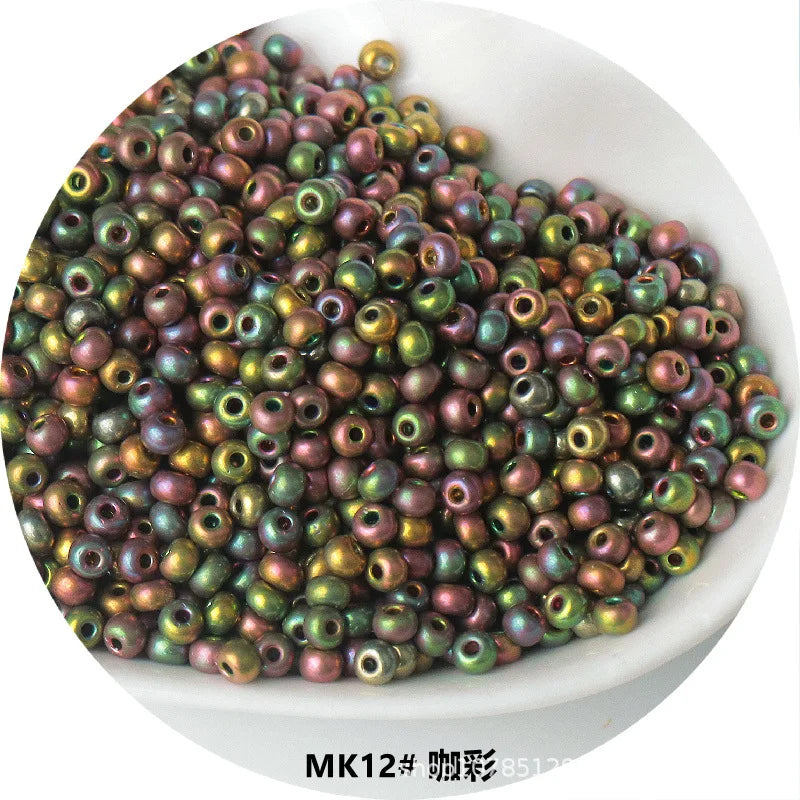 A pile of small, round electroplated metallic glass beads in various shades of green and bronze.