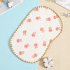 A white embroidered flat pillow with pink bunny designs on a light blue background.