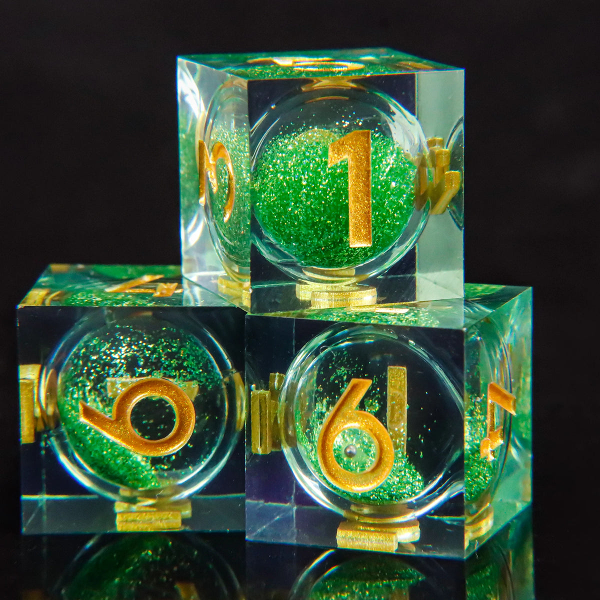 A set of green resin dice cubes with golden Elven numbers, featuring the number one.