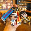 A keychain featuring miniature figures of Michael Jackson in various dance poses and outfits.