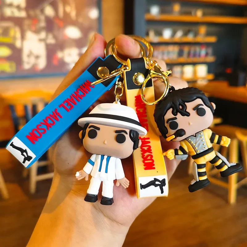 A keychain featuring miniature figures of Michael Jackson in various dance poses and outfits.