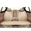 Interior view of a car seat with beige quilted cushions and headrests.