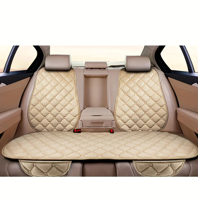 Interior view of a car seat with beige quilted cushions and headrests.
