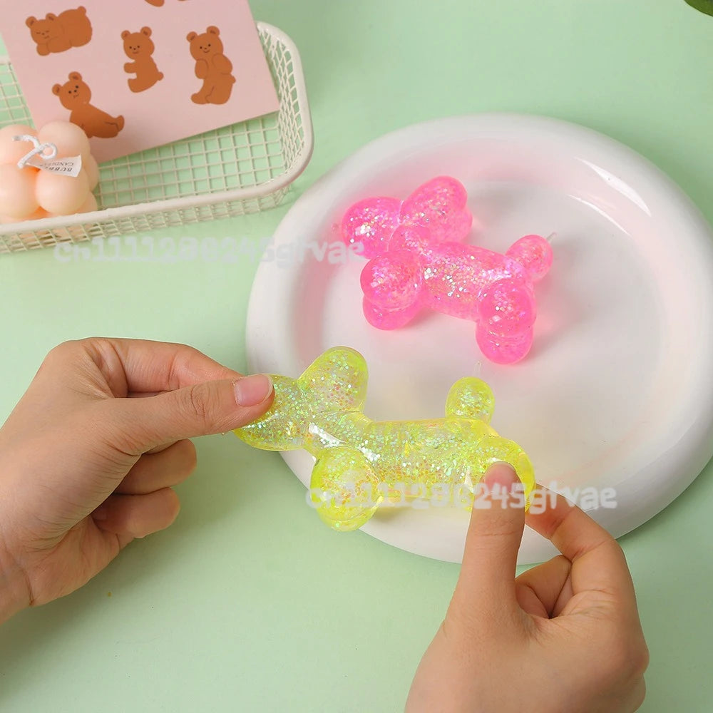 Hands are squeezing translucent pink and yellow squishy stress balls on a white plate.