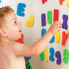Un enfant interagit avec un mur d'assemblages de lettres colorées.