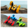 A yellow 4WD remote control stunt car is positioned on a rock, with a red climbing accessory and green wheels nearby.