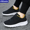 A pair of black breathable mesh kids' sneakers with yellow accents shown from the side.