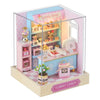 A DIY wooden miniature dollhouse kit shaped like a candy shop with pink and blue accents.