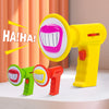 A yellow toy voice changer with a pink mouth, next to two smaller green and red versions.