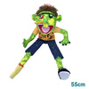 A green, furry hand puppet with large eyes and a mouth showing teeth, wearing an orange shirt and blue pants.