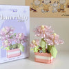 A pink and green miniature flower bouquet building block set displayed next to its packaging.