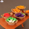 A miniature dollhouse vegetable basket play set filled with various colorful vegetables like carrots, peppers, and leafy gree