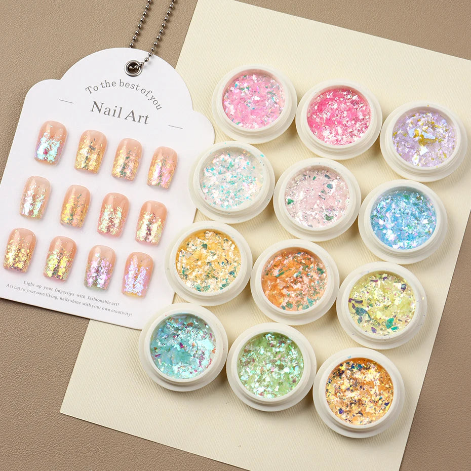 A set of iridescent opal and mermaid chrome nail glitter pigments displayed in small jars on a card.