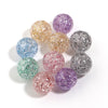 A collection of round loose spacer beads in various glitter colors including purple, gold, blue, and silver.