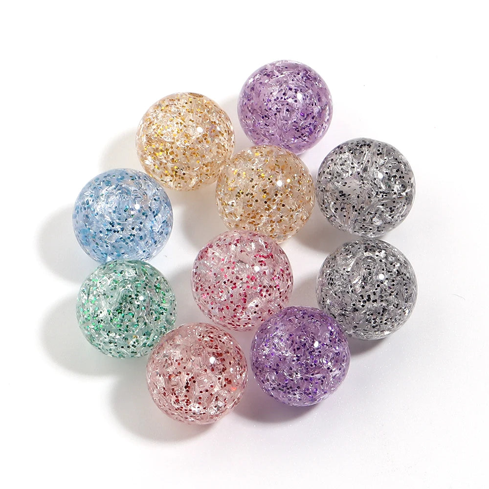 A collection of round loose spacer beads in various glitter colors including purple, gold, blue, and silver.
