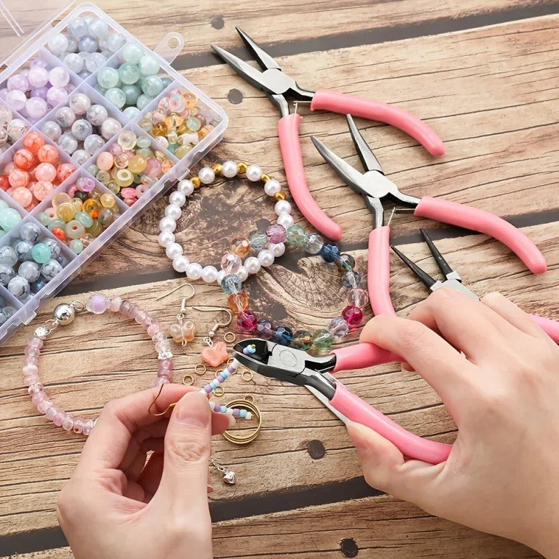 A hand is using pliers and nippers to work on beads and wire within a clear storage box.