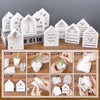 A set of white silicone molds shaped like houses, hearts, and Christmas trees for ornaments.