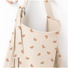 A beige breathable muslin nursing cover with a textured pattern and adjustable neckline.